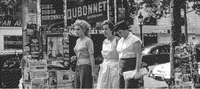 Vintage photo of women passing by a newspaper kiosk.